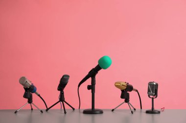 Microphones on table against pink background. Journalist's work clipart
