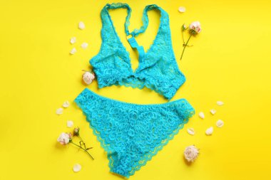 Düz kompozisyon ve sarı arka planda seksi kadın iç çamaşırı.