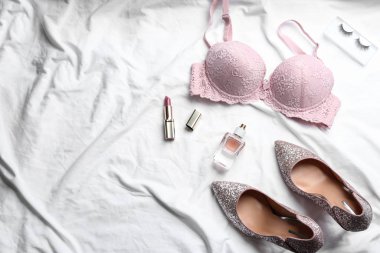 Beyaz kumaş üzerinde seksi kadın iç çamaşırları olan düz bir kompozisyon.