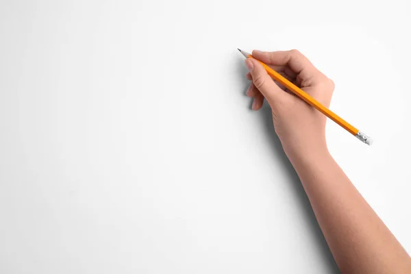 Жінка тримає олівець на білому тлі, вид зверху — стокове фото