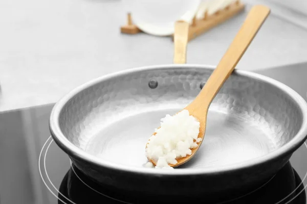 Frying pan with coconut oil on induction stove, closeup. Healthy — Stock Photo, Image