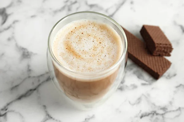 Delicious coffee and wafers for breakfast on white marble table