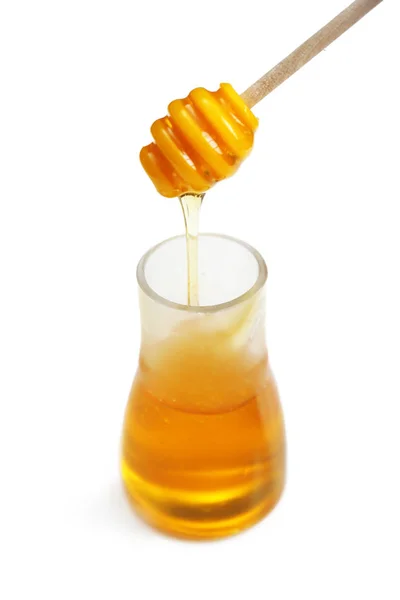 Miel dans un bocal en verre et trempette sur fond blanc — Photo
