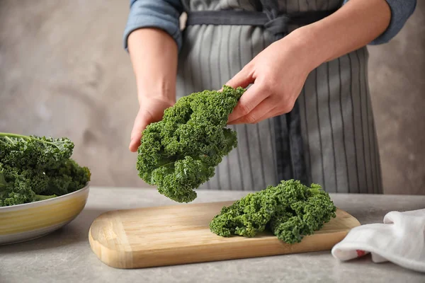 Kvinna Som Håller Färska Grönkålsblad Över Ljusgrått Bord Närbild — Stockfoto