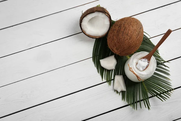 Composición plana con aceite de coco sobre mesa de madera blanca, spa —  Fotos de Stock