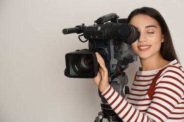 Beyaz arkaplanda profesyonel video kamerası olan operatör
