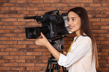 Duvarın yanında profesyonel video kamerası olan bir operatör