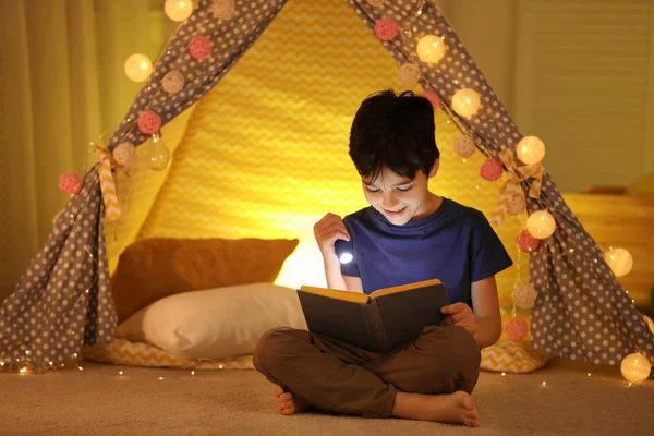 Preteen chlapec s baterkou čtení knihy doma — Stock fotografie