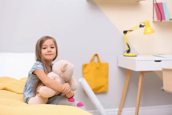 Cute little girl playing with toy bear at home — 스톡 사진