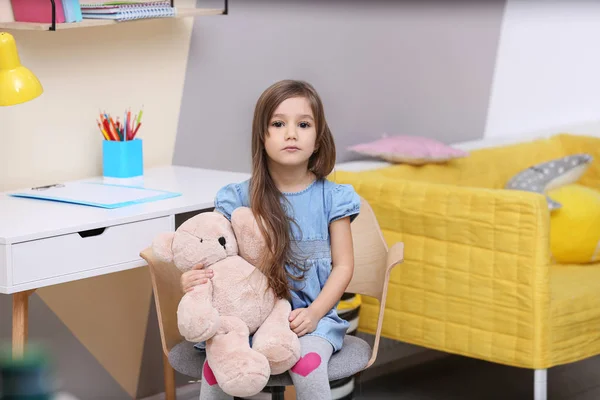 Niedliches kleines Mädchen spielt zu Hause mit Spielzeugbär — Stockfoto