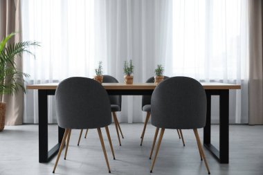 İçinde sandalye ve masa olan modern bir oda.