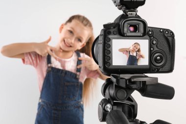 Beyaz arkaplana karşı video kaydeden sevimli küçük blogger, kameraya odaklan