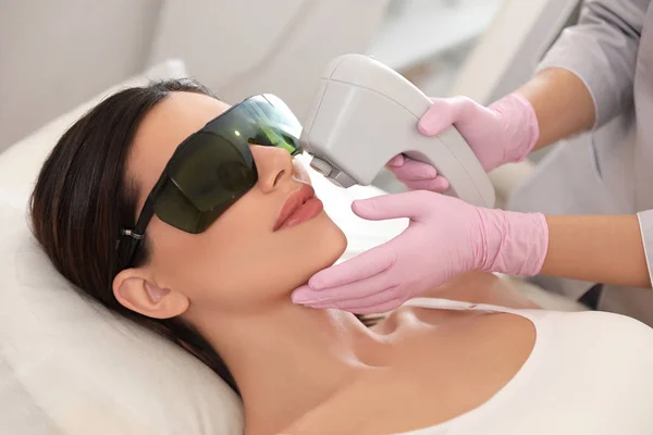 Young woman undergoing laser epilation procedure in beauty salon — Stock Photo, Image