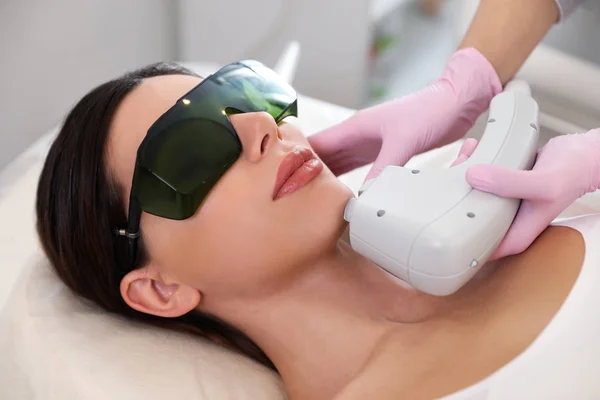 Young woman undergoing laser epilation procedure in beauty salon — Stock Photo, Image