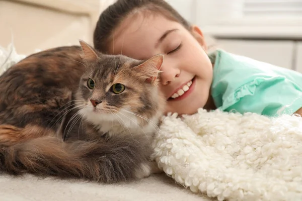 Petite fille mignonne avec chat couché sur le tapis à la maison. Premier animal de compagnie — Photo