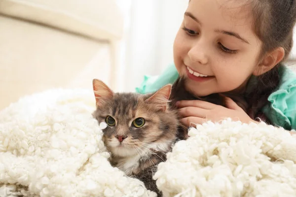 Niedliches kleines Mädchen mit Katze zu Hause liegend. erstes Haustier — Stockfoto