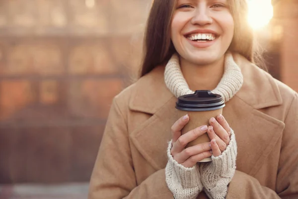 Mujer joven con taza de café en la calle de la ciudad en la mañana, closeu — Foto de Stock