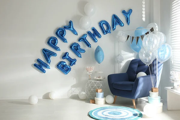 Phrase HAPPY BIRTHDAY made of blue balloon letters in decorated room