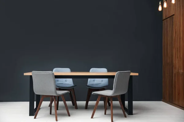 Современный пустой деревянный стол возле черной стены — стоковое фото