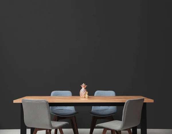 Μοντέρνο τραπέζι με διακοσμητικούς ανανάδες κοντά σε μαύρο τοίχο — Φωτογραφία Αρχείου