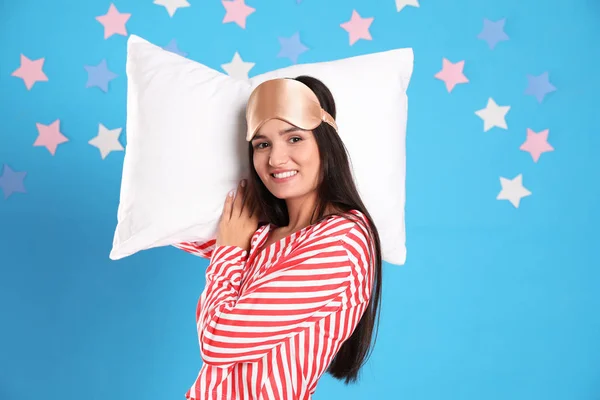 Beautiful woman with pillow on light blue background. Bedtime — Stock Photo, Image