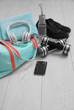 Spor çantası ve spor malzemeleri ahşap zeminde.