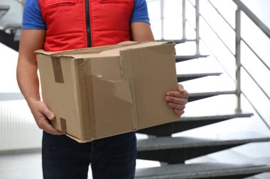 Zarar görmüş karton kutulu kurye içeride, yakın plan. Kalitesiz dağıtım hizmeti