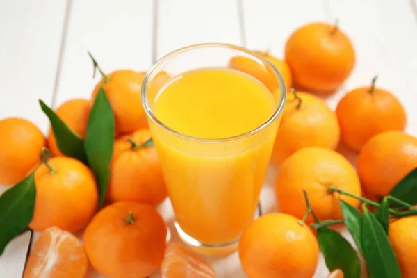 Glas frischen Mandarinensaft und Früchte auf weißem Holztisch — Stockfoto