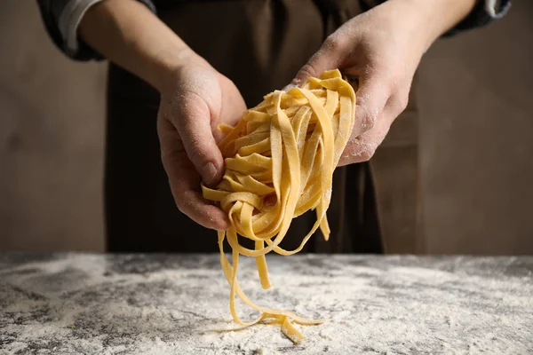 Mujer sosteniendo pasta en la mesa, vista de cerca — Foto de Stock