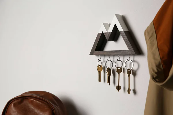 Dřevěný držák klíčů na světelné stěně uvnitř. Mezera pro text — Stock fotografie