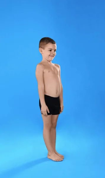 Roztomilý chlapeček ve spodním prádle na světle modrém pozadí — Stock fotografie