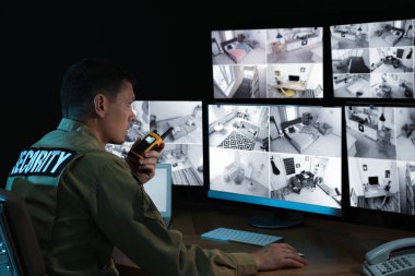 Mobil vericili güvenlik görevlisi modern CCTV 'yi izliyor. 