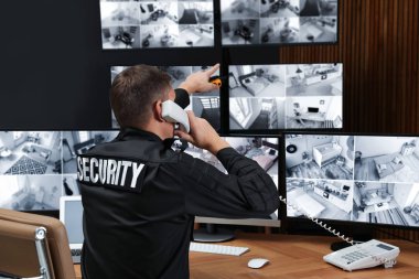 Güvenlik görevlisi iş yerinde telefonla konuşuyor.