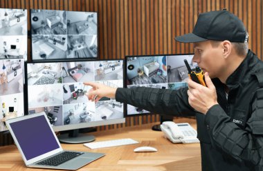 Mobil vericili güvenlik görevlisi modern CCTV 'yi izliyor. 