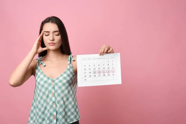 Ung Kvinna Innehav Kalender Med Markerade Menstruationscykel Dagar Rosa Bakgrund — Stockfoto