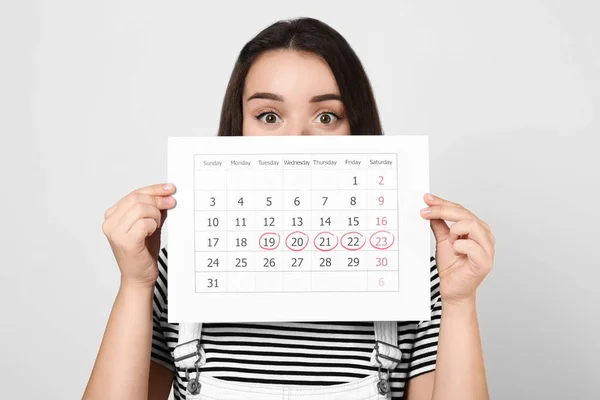 Young Woman Holding Calendar Marked Menstrual Cycle Days Light Background — Stock Photo, Image