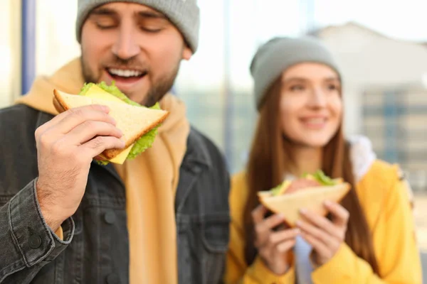 Szczęśliwa młoda para z kanapkami na ulicy miasta — Zdjęcie stockowe