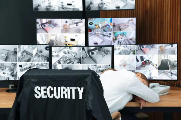 Tired security guard sleeping at workplace in office — Stock Photo, Image