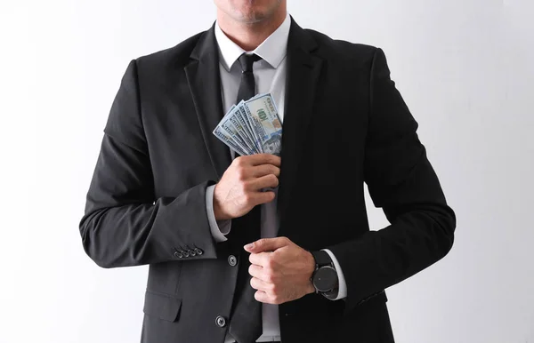 Man with bribe money on light background, closeup — Stock Photo, Image