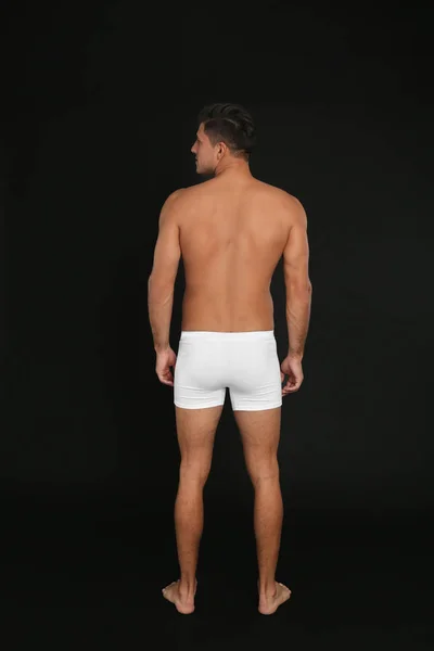 Man in underwear on black background, back view — Stok Foto