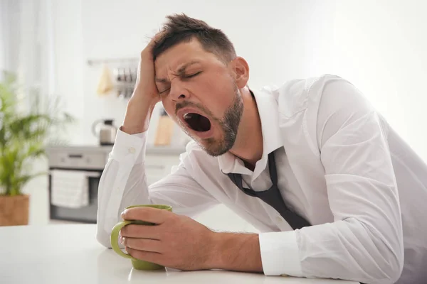 Homme endormi avec tasse de boisson à la maison le matin — Photo