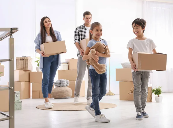 Happy family in room with cardboard boxes on moving day — Stock Photo, Image