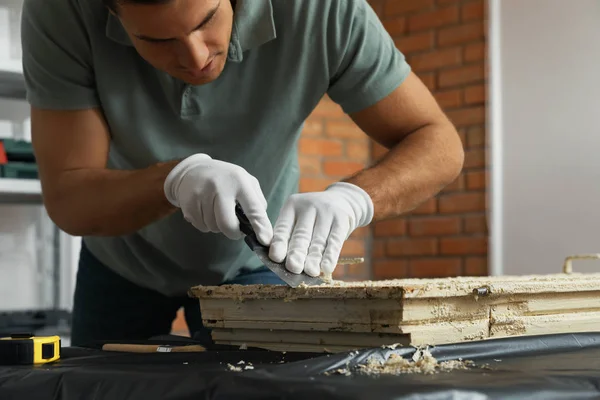 Homem reparando janela danificada velha na mesa dentro de casa — Fotografia de Stock