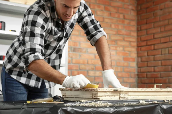 Man repareert oude beschadigde raam aan tafel binnen — Stockfoto