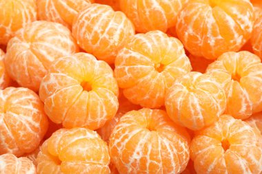 Arka plan olarak soyulmuş taze olgun mandalinalar, yakın plan