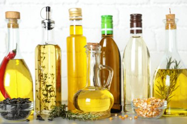 Gri masadaki şişelerde farklı pişirme yağları
