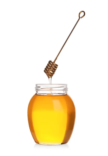 Honey dripping from dipper into jar isolated on white — Stock Photo, Image