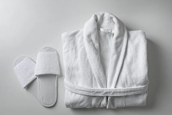 白色背景的干净折叠浴衣和拖鞋，平铺 — 图库照片