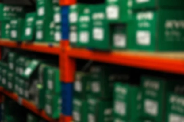 Blurred view of shelving unit with merchandise in modern wholesale shop, closeup