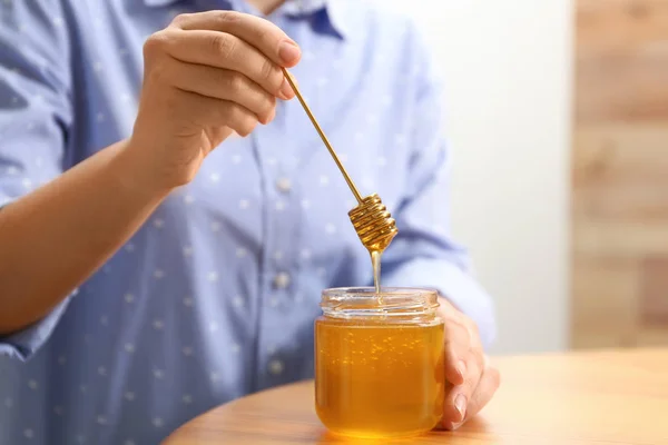 Frau Hält Honiglöffel Über Glas Holztisch Nahaufnahme — Stockfoto